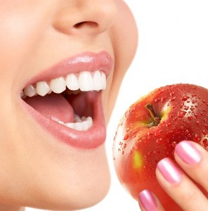 female face with mouth open to take a bite of an apple