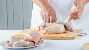 chef cutting raw chicken