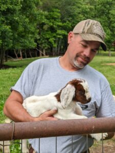 farmer holding baby goat