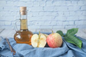 bottle of vinegar and apples in basket